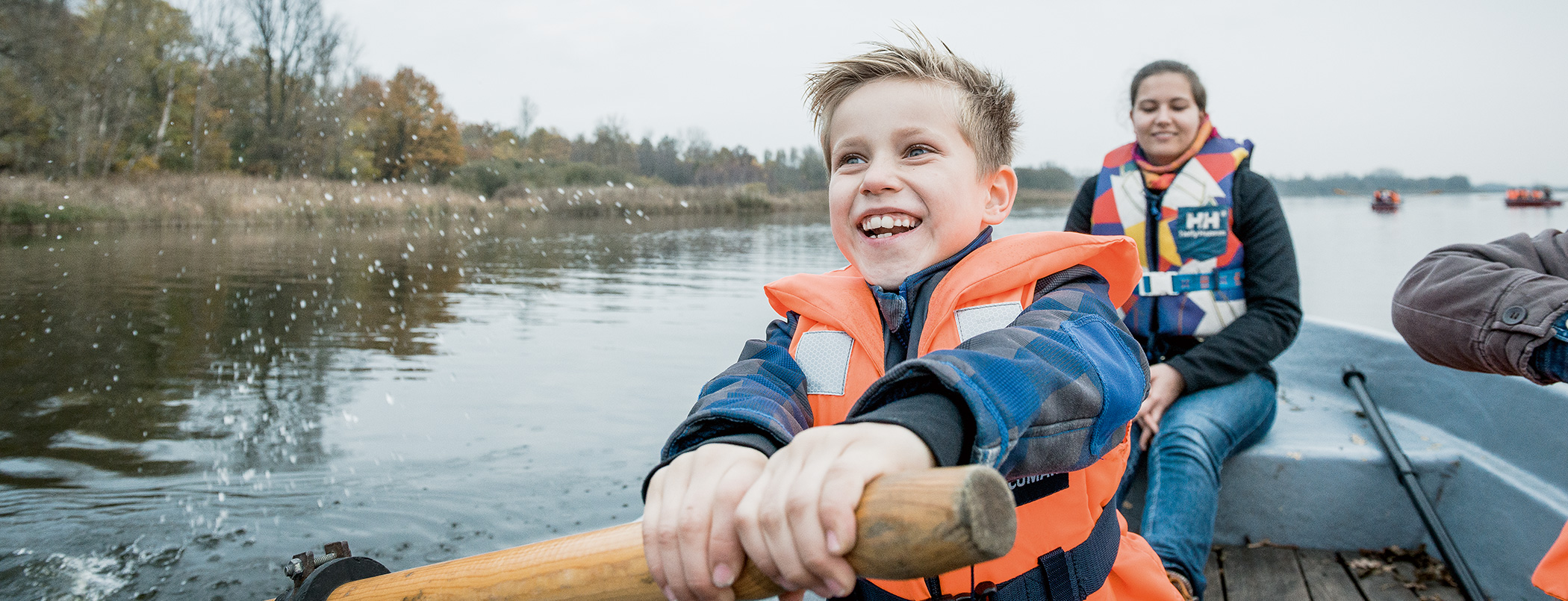Ein Kind und eine Frau rudern auf einem See.