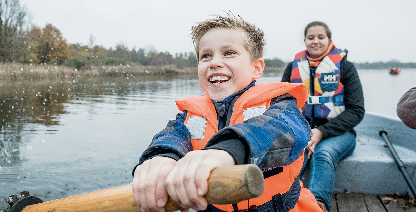 Ein Kind und eine Frau rudern auf einem See.